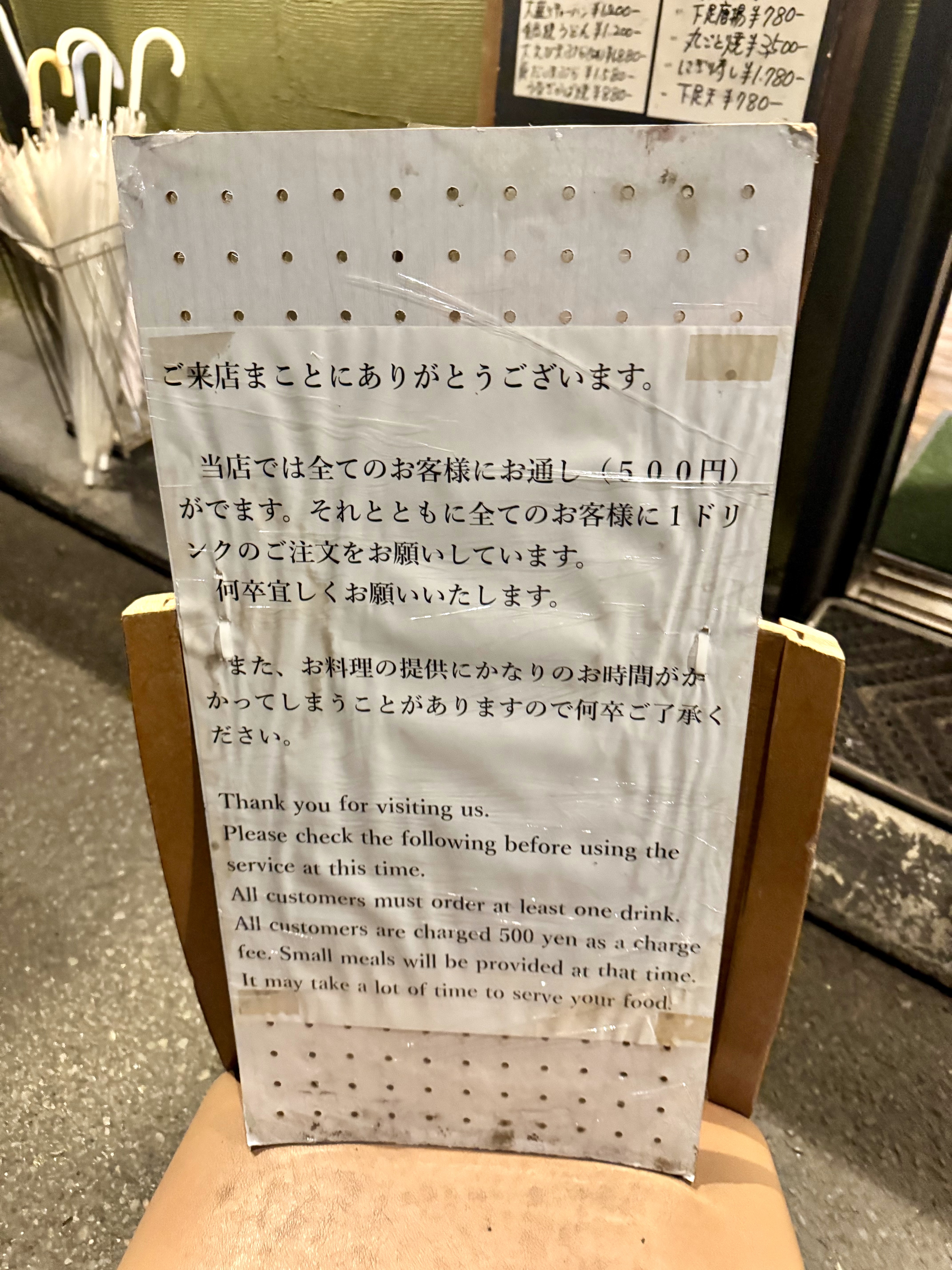 扉の前にお通し台がかかる旨書かれた案内がある